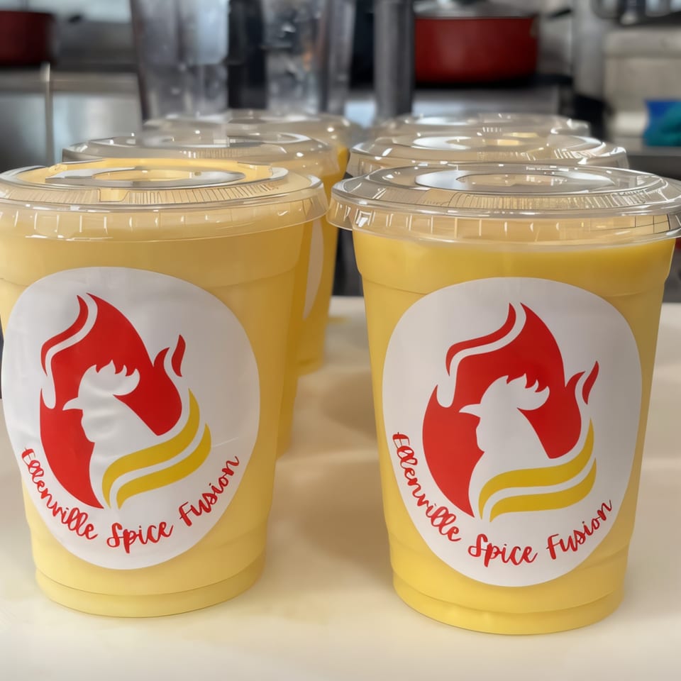Several Ellenville Spice Fusion mango lassi drinks with branded labels on a counter.
